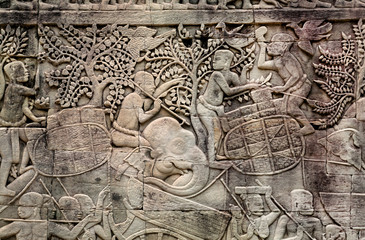 Fototapeta na wymiar Harvest time, stone faces and elephants on the 12th century relief of Bayon temple, Cambodia. Historical artwork on wall of Khmer landmark in Angkor. UNESCO world heritage site