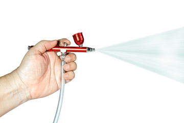 Red airbrush spray tool in hand for paintingg hobby or work for art .