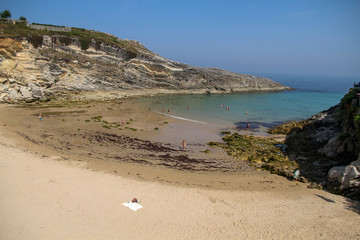 Small beach with people in the sun. El Sablón in Llanes, Asturias