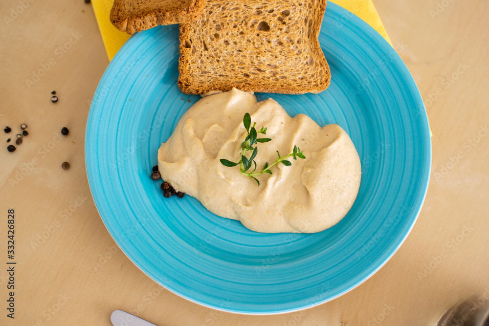 Wall mural delicious homemade hummus on a blue plate and slices bread