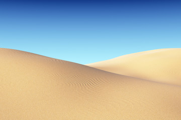 Smooth sand dunes with waves under blue sky