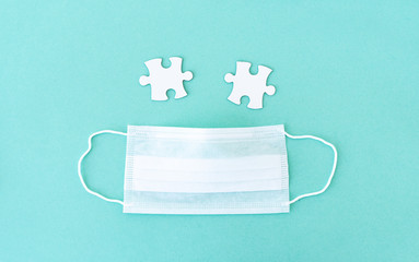 Two empty jigsaw puzzle pieces near medical mask