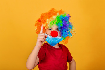 A child clown in a protective mask urges you to carefully examine the signs of coronavirus.