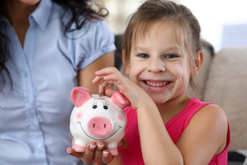Child putting coin in thrift-box