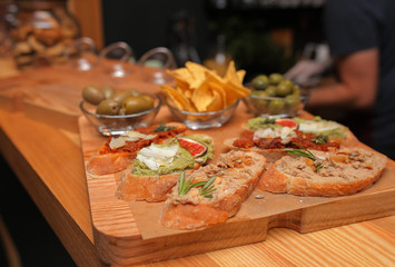 sandwiches on a wooden tray with chips