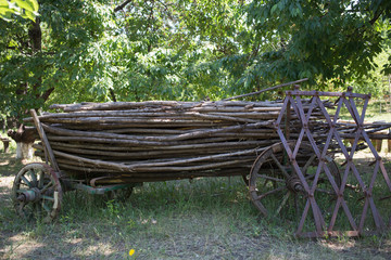 Vintage wooden cart is loaded with poles.