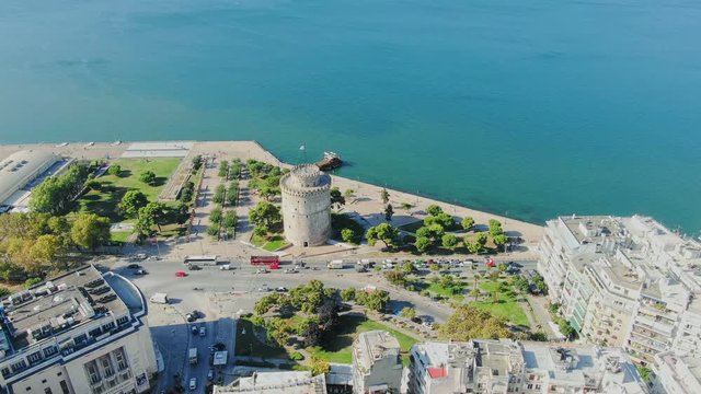 Aerial shot view, flying above Greek town Thessaloniki and famous UNESCO world heritage White tower, historic monument from medieval roman empire ages. 