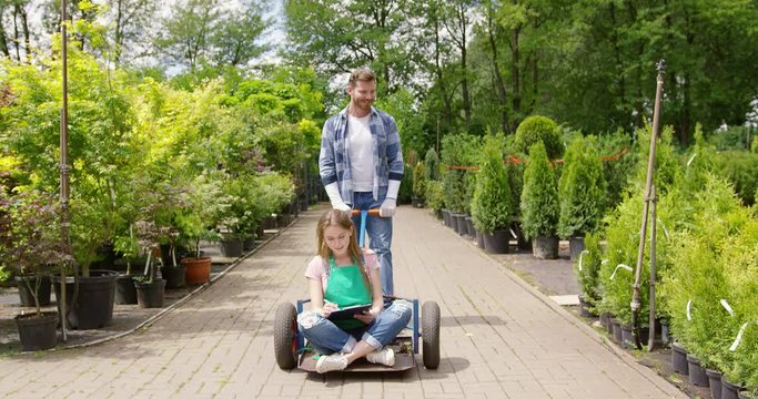 Woman gardner sitting on wagon in garden and doing paperwork