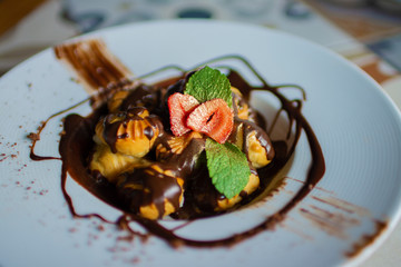 Beautifully served profitroles with mint