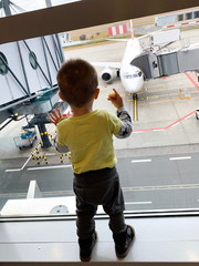 Kid watching a plane in the airport