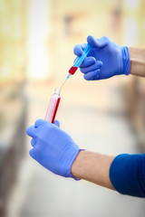 a In the hands of a test tube with blood for analysis of the virus. Covid-19 is a danger to the infectious air population.