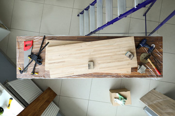 On workbench are wooden veneered sheets and tools