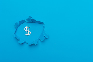 Dollar sign in paper cut hole. Blue background