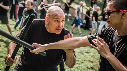 Large group of students practice filipino eskrima stick fight techniques