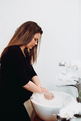 Caucasian Pregnant woman washing hands at home using disinfectant and soap, tap water and cleaning cosmetics