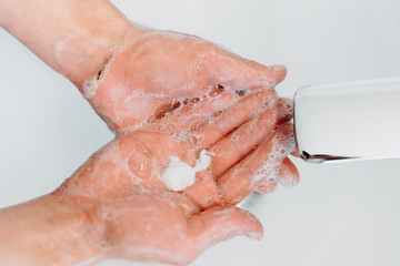 Close up details of hand soap, disinfectant and antimicrobial soap in woman hands while washing