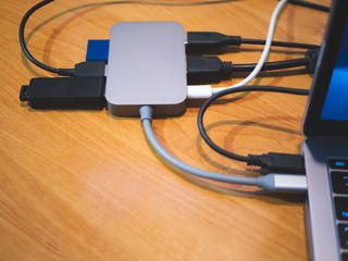 usb type-c hub connected to laptop with lot of cables connected for peripheral computer device equipment