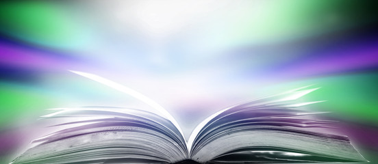 The blurred book that is bewitched with magic, the magic light in the dark, with the bright light shining down as the power to search for knowledge. For research and use as a blurred background