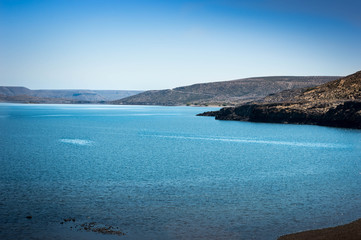 Obraz premium Turquoise lake and mountains in the background. I walk along the Neuquén highway, Argentina.