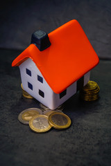 Modellhaus mit Euros vor schwarzem Hintergund zur  immobilienfinanzierung