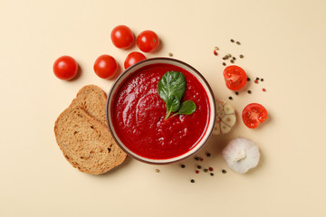 Tomato cream soup on beige background, top view