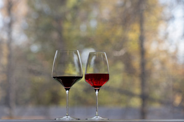 Two wine glass with the red wine on a sill.
