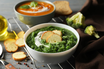 Sweet potato and broccoli cream soups on wooden background, close up