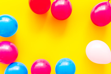 Colorful balloons frame on yellow background top-down frame copy space