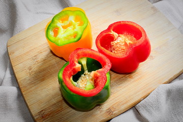 Miks kolorowych papryk na drewnianej desce © Tomek