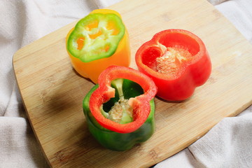 Miks kolorowych papryk na drewnianej desce © Tomek