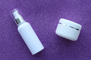 Cans of cream on a shiny purple background