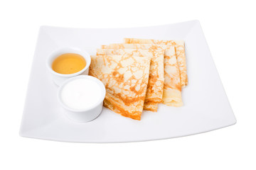 Breakfast of pancakes with sour cream and honey.