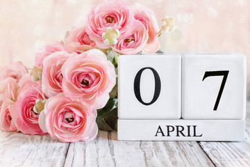 Fototapeta premium White wood calendar blocks with the date April 7th. Selective focus with blurred background.