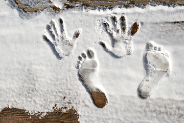 retro style wooden background. The first snow fell on it. Left human footprints of hands and feet