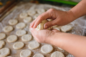 Woman in the kitchen prepares dumplings for breakfast, Ukrainian folk dish.