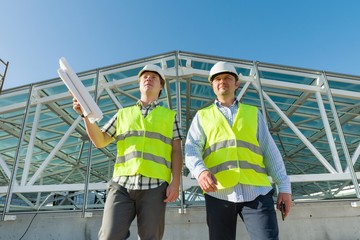 Industrial portrait of two men working at construction site