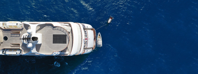 Aerial drone ultra wide top down photo luxury mega yacht with wooden deck anchored in Aegean deep...