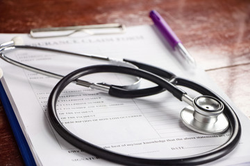 The stethoscope put on blurred Insurance claim form,blurry light around