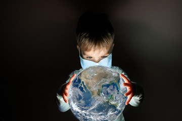 little cute boy in medical mask holding a luminous planet Earth in her hands. Elements of this image furnished by NASA.