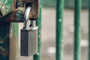 Closed and locked door grill with silver padlock.