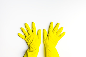 two hands in yellow latex gloves on a white background. cleanliness