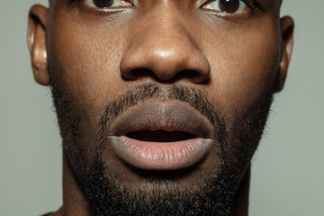 Shocked, wondered. Close up of face of beautiful african-american young man, focus on mouth. Human...