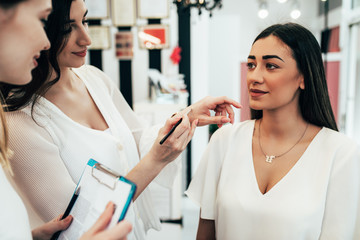 Professional makeup artist teaching student in makeup school.