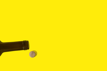 Brown neck of wine bottle . Cork from bottle. Isolated on yellow background. Flat lay, top view.