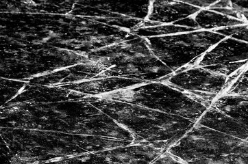 White cracks in the ice cover in black and white style closeup
