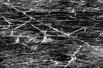 Ice cover of the lake with many cracks in black and white style