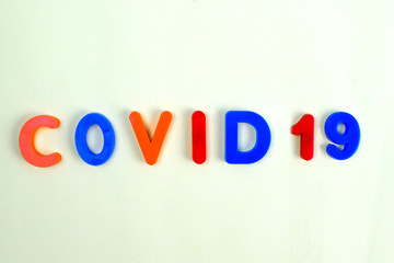COVID-19 written in different colored letter blocks on a white background