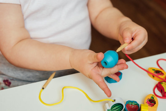 Child Putting Beads On A String. Bead Stringing Activity. Fine Motor Skills Development. Lacing, Threading.