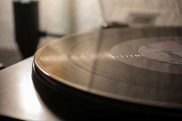 Vintage record player with vinyl disc, close to light.