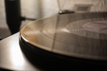 Obraz premium Vintage record player with vinyl disc, close to light.